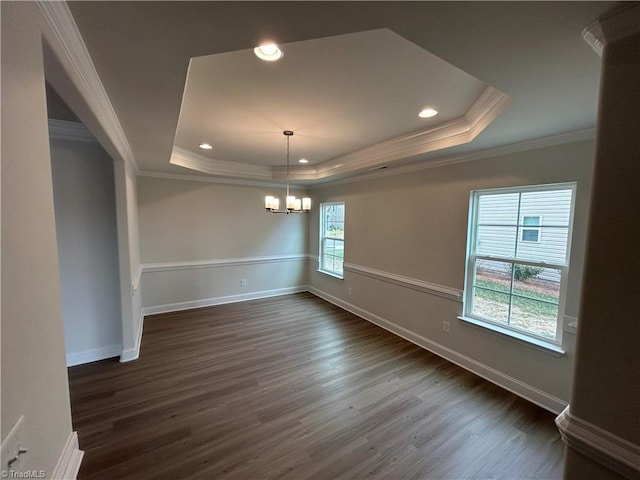 unfurnished room with ornamental molding, a tray ceiling, dark hardwood / wood-style flooring, and a notable chandelier