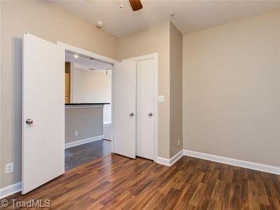 411 W Washington St Unit 309, Greensboro, NC 27401 - unfurnished bedroom featuring wood finished floors, baseboards, and ceiling fan
