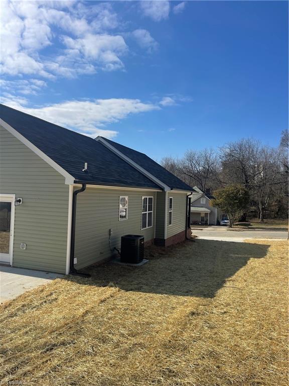 exterior space with central AC and a yard