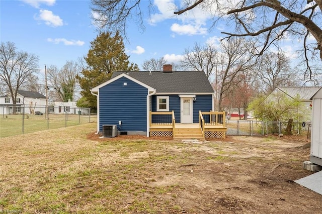 back of property with a wooden deck, a lawn, fence private yard, and a chimney