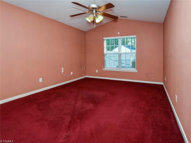 empty room with lofted ceiling, ceiling fan, and dark carpet