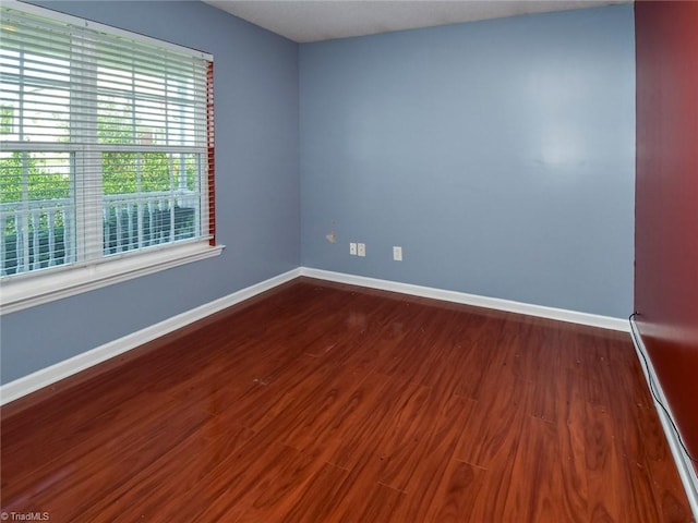 unfurnished room with dark wood-type flooring