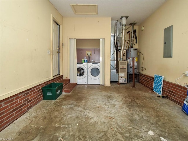 washroom featuring electric panel, brick wall, gas water heater, laundry area, and independent washer and dryer
