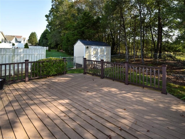 deck featuring an outdoor structure, a shed, and a fenced backyard