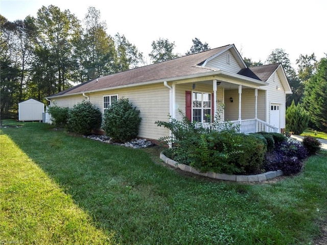 view of side of property with covered porch, a lawn, and a shed