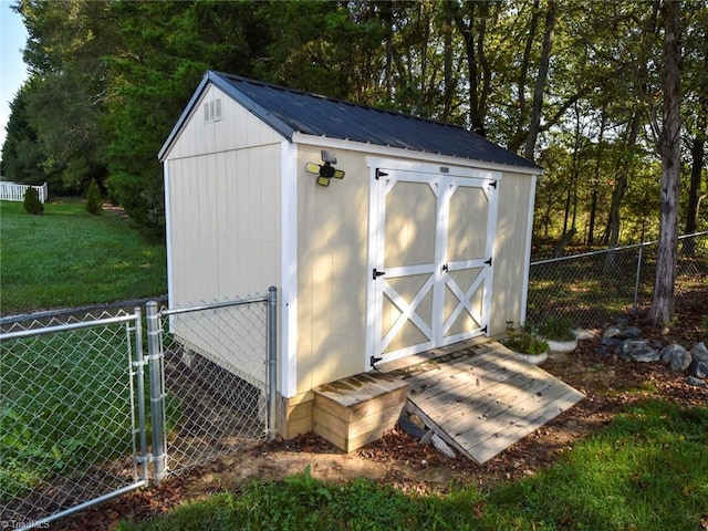 view of shed featuring fence and a gate