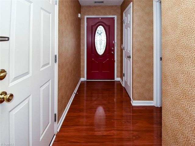 doorway to outside featuring visible vents, baseboards, and wood finished floors