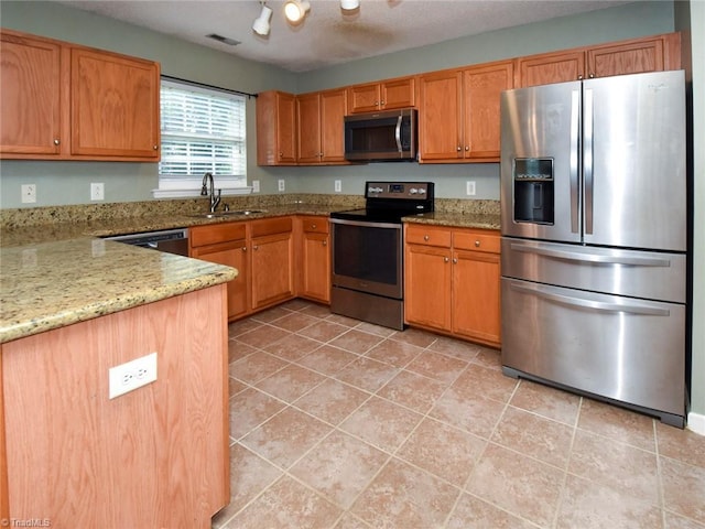 kitchen featuring stainless steel appliances, visible vents, light tile patterned floors, a sink, and light stone countertops