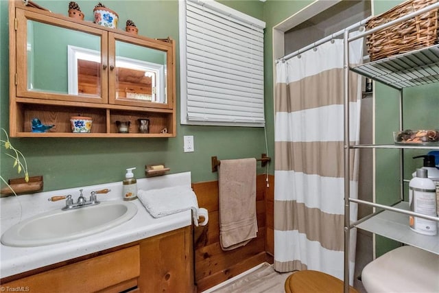 bathroom featuring hardwood / wood-style floors, toilet, and vanity with extensive cabinet space