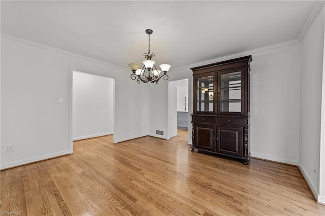 unfurnished dining area with an inviting chandelier, baseboards, crown molding, and light wood-style floors