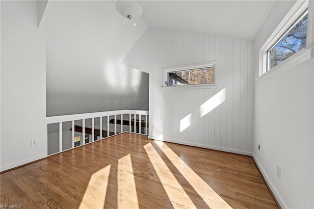 bonus room featuring vaulted ceiling, baseboards, and wood finished floors