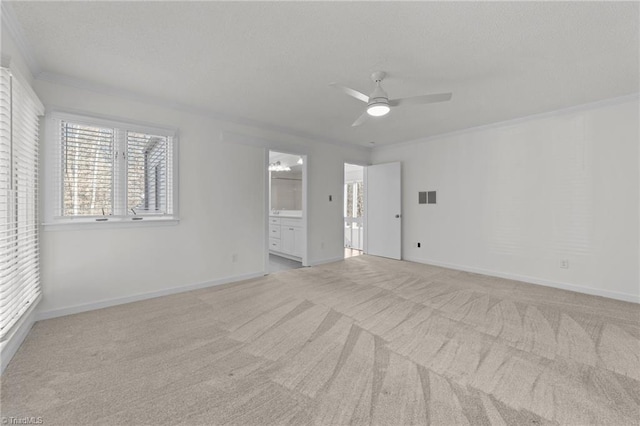 carpeted empty room with a ceiling fan, baseboards, visible vents, a textured ceiling, and crown molding