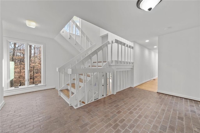 stairs with brick floor, baseboards, and recessed lighting