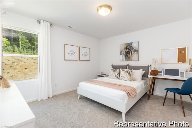 bedroom featuring visible vents, baseboards, and light colored carpet