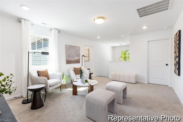 living area featuring light colored carpet, visible vents, baseboards, and recessed lighting