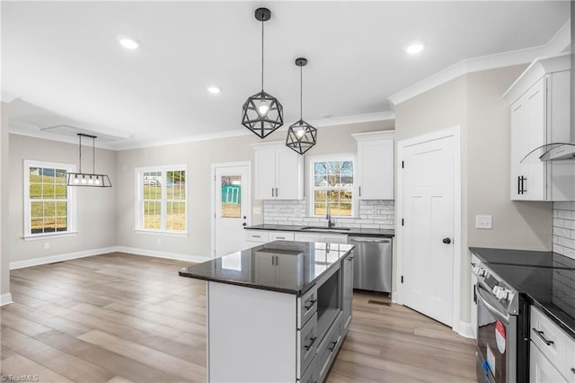 kitchen featuring tasteful backsplash, decorative light fixtures, a kitchen island, white cabinetry, and stainless steel appliances