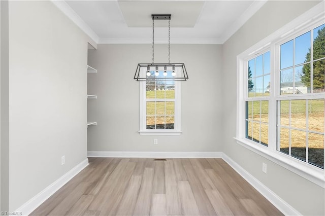 unfurnished dining area featuring an inviting chandelier, light hardwood / wood-style flooring, plenty of natural light, and ornamental molding