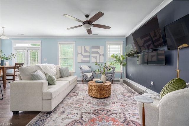 living room featuring crown molding, baseboards, a ceiling fan, and wood finished floors