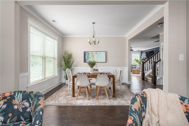 dining room featuring dark wood-type flooring, stairs, a wainscoted wall, and a chandelier