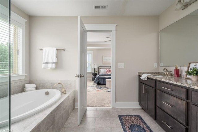 ensuite bathroom featuring vanity, tile patterned flooring, visible vents, a bath, and ensuite bath