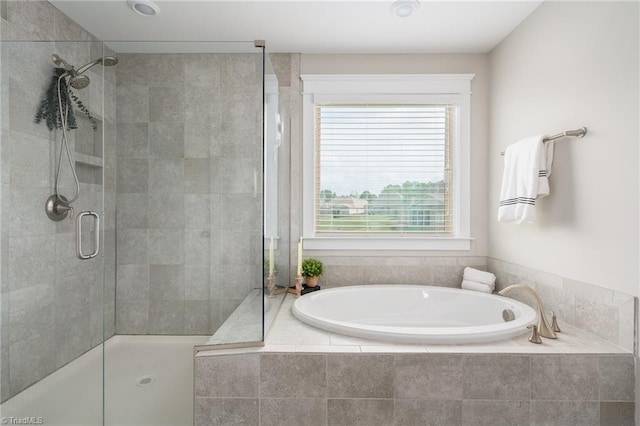 bathroom featuring a garden tub and a shower stall