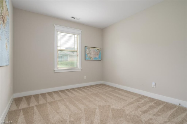 carpeted empty room featuring baseboards and visible vents