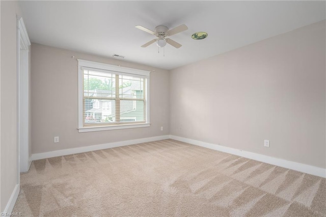 spare room with baseboards, carpet flooring, a ceiling fan, and visible vents