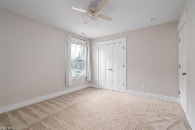 unfurnished bedroom with carpet floors, baseboards, visible vents, and a closet