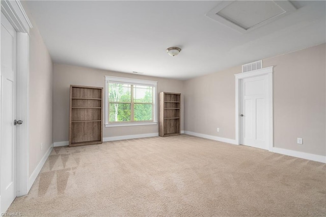unfurnished room featuring baseboards, light carpet, attic access, and visible vents