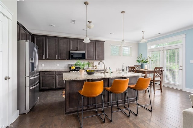 kitchen with a kitchen breakfast bar, dark wood-style flooring, visible vents, dark brown cabinets, and stainless steel appliances