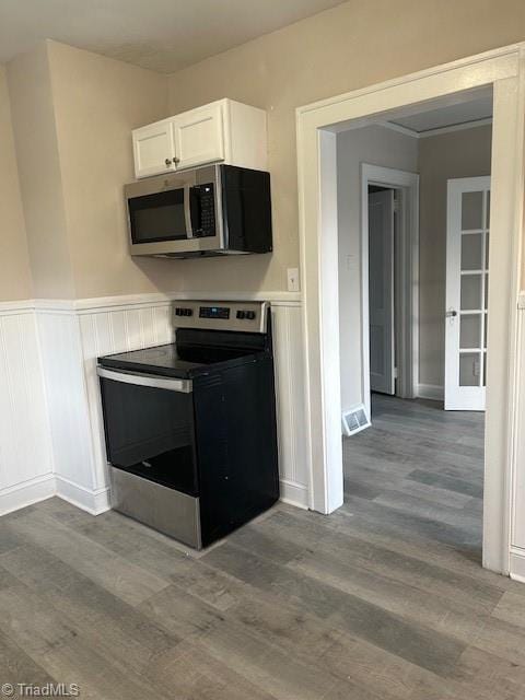 kitchen with stainless steel appliances, visible vents, dark wood finished floors, and white cabinets