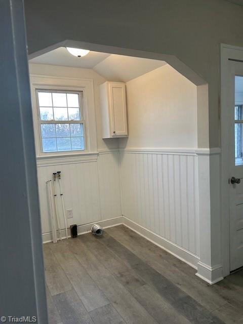 clothes washing area with wood finished floors