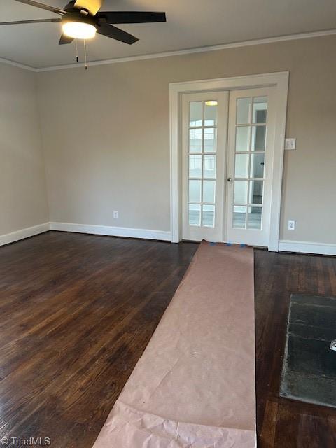 unfurnished room featuring dark wood finished floors, baseboards, and ornamental molding