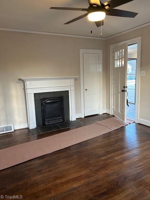 unfurnished living room with wood finished floors, visible vents, baseboards, a fireplace with flush hearth, and crown molding