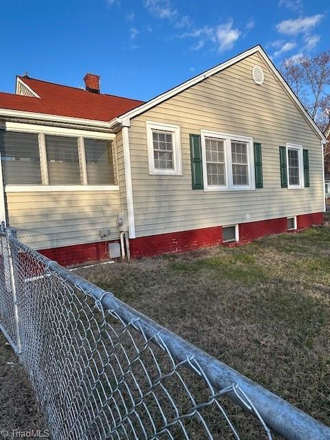 view of home's exterior with fence and a chimney