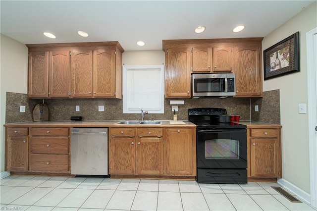 kitchen with stainless steel appliances, backsplash, light tile patterned floors, and sink