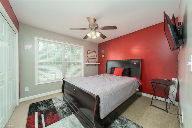 bedroom featuring ceiling fan, a closet, and light carpet