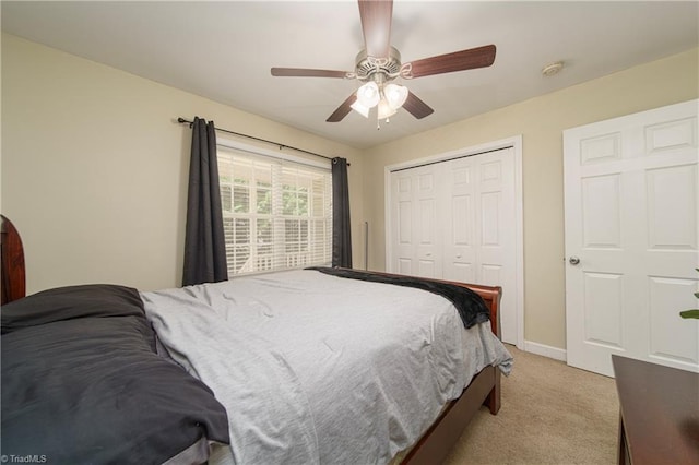 carpeted bedroom featuring ceiling fan and a closet