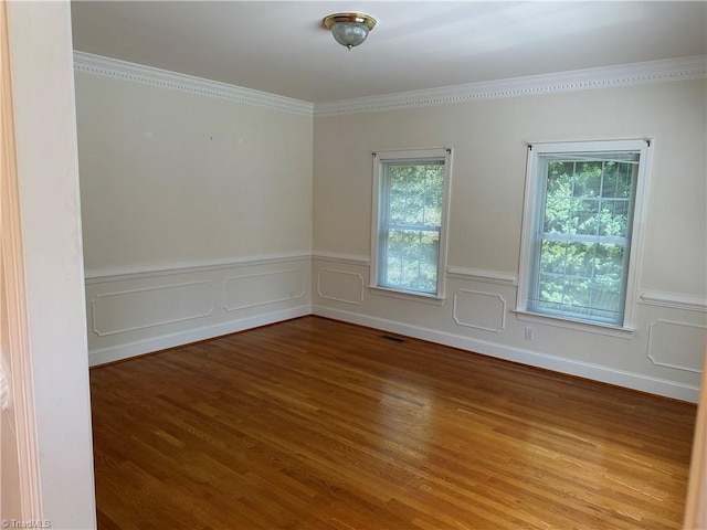 empty room with wood-type flooring and ornamental molding