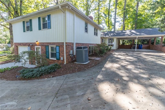 view of home's exterior with a carport, a garage, and central AC