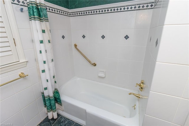 bathroom featuring shower / bath combo with shower curtain and tile walls