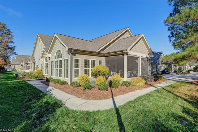 view of side of home with a lawn and a sunroom