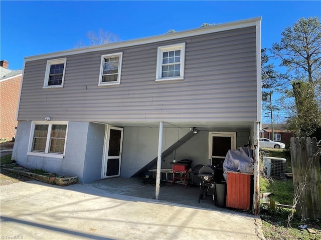 back of house featuring central AC unit, driveway, and a patio area