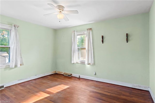 spare room with a ceiling fan, baseboards, and wood finished floors