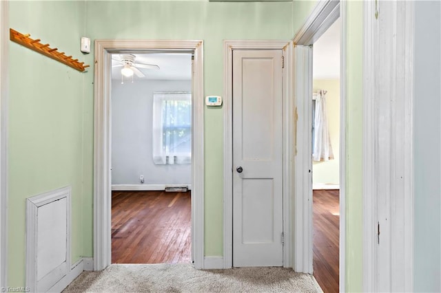 corridor featuring baseboards and carpet floors