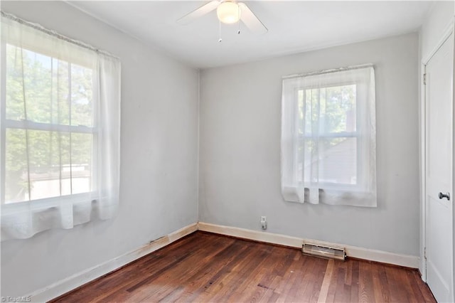 empty room featuring plenty of natural light, wood finished floors, baseboards, and a ceiling fan
