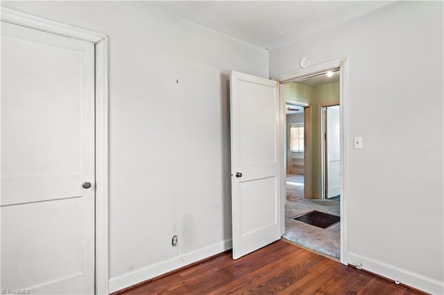 unfurnished bedroom featuring dark wood finished floors and baseboards