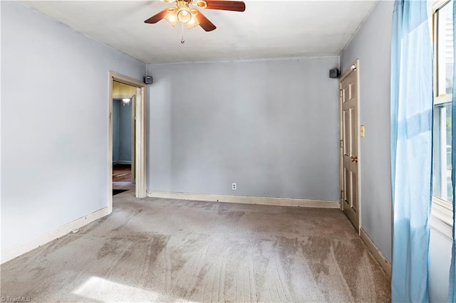 unfurnished room with carpet, a ceiling fan, and baseboards