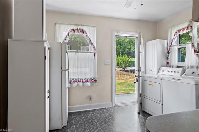 laundry room featuring washing machine and clothes dryer and baseboards