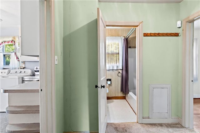 full bathroom featuring washer and clothes dryer and baseboards